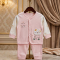 Pink baby outfit with cartoon design on a hanger against a decorative background