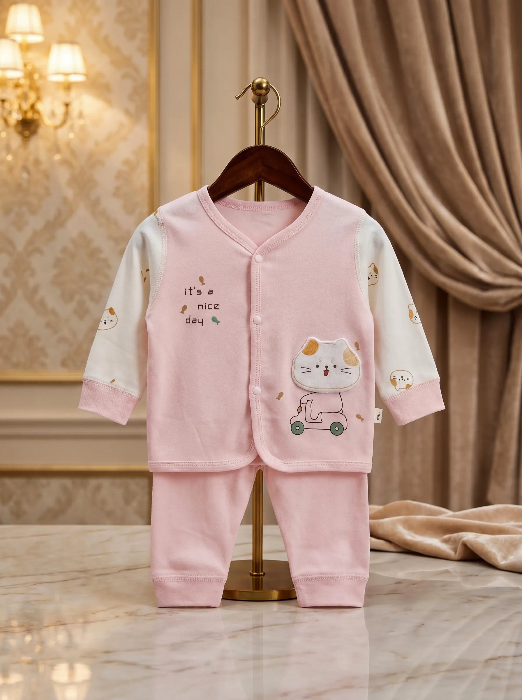 Pink baby outfit with cartoon design on a hanger against a decorative background